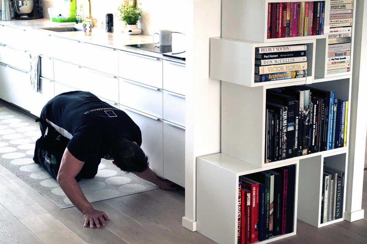 besiktningsman tittar noggrant på köksgolv